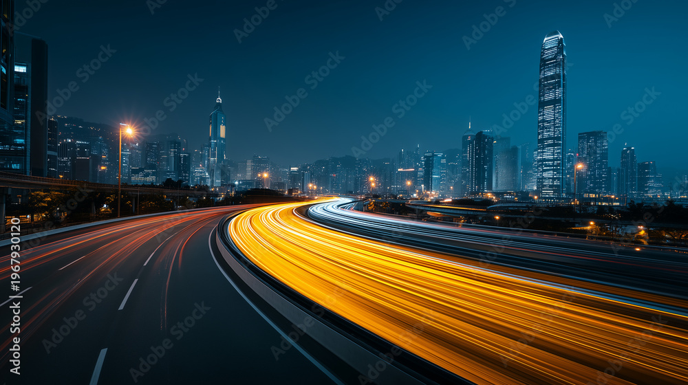 Fototapeta premium A city highway at night with traffic light trails curving through a modern metropolitan area with skyscrapers in the background