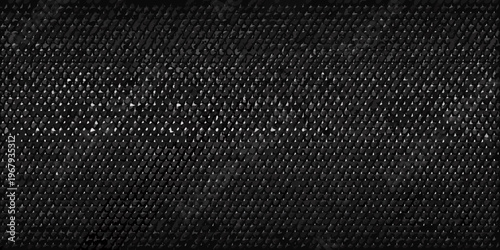 Close up of a dark textured fabric with a repeating geometric pattern