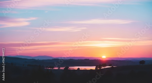 A serene sunset over a body of water with hills