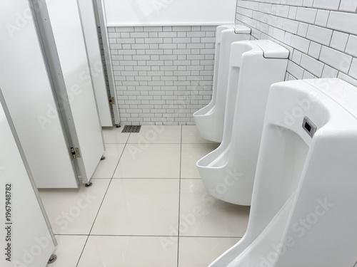Photos 清潔な白い男性用トイレの小便器が並ぶ室内空間