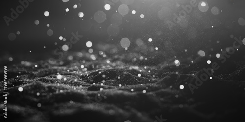 Abstract image of dark textured terrain covered in white dust particles or snow with bright, scattered bokeh lights
