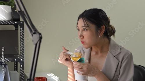 Office worker eating instant noodles at desk, fast meal choice highlighting convenience versus long term health risks.