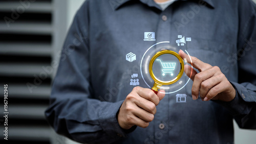 Businessman using magnifying glass to analyze online shopping cart and e-commerce marketing data.