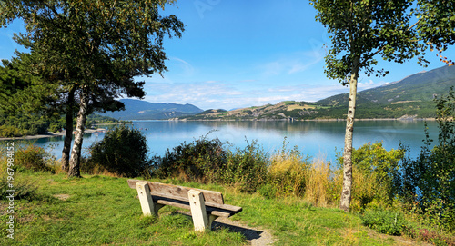Schilderij op canvas Wooden bench overlooking Lac de Serre-Poncon in French Alps, Alpes-de-Haute-Provence, France, Europe
