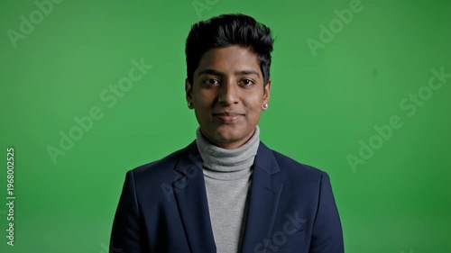 Confident professional man in suit smiling against green background