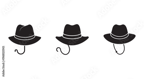 Three black hats with chin straps hanging on hooks  isolated on white background