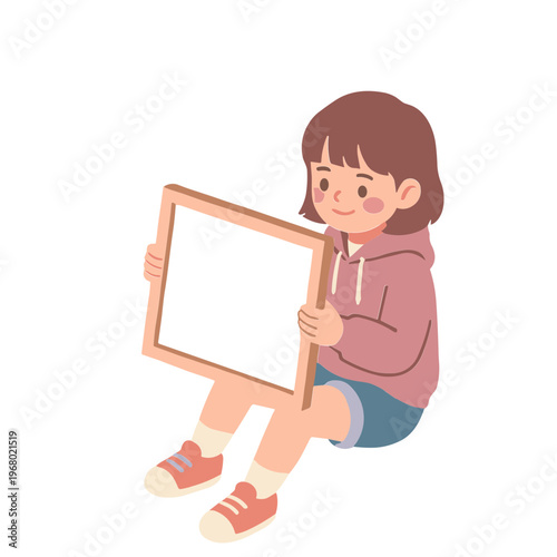 A young girl sitting on floor holding blank picture frame indoors