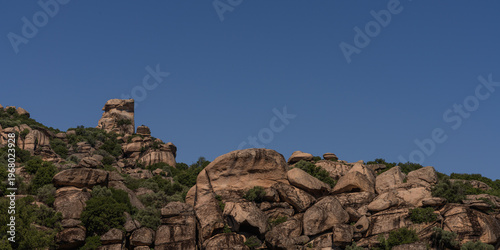 Fotografie Rocky Landscape with Boulder Formations Against Clear Blue Sky