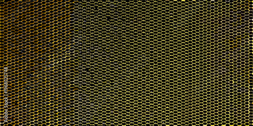 A striking close up view of a dark honeycomb with golden highlights