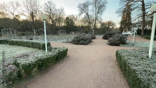 Wallpaper Mural Icy white frost covers green hedges and garden beds at a path crossing. The cold morning air and empty park walkways create a peaceful, quiet feeling of winter solitude. Torontodigital.ca