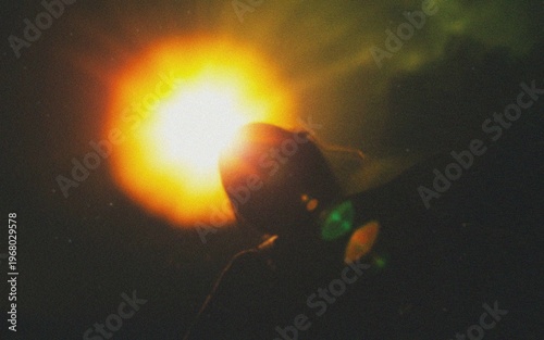 Fényképezés Silhouette of person against dramatic sunset with vibrant lens flare and moody a