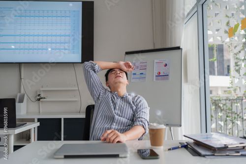 Young businessman experiencing work burnout and stress in office