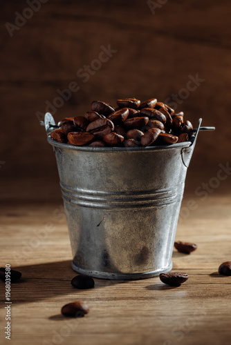 Silver Bucket Filled with Coffee Beans on Wooden Surface