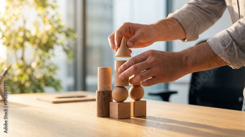 Fotografía Creative hands carefully building a diverse structure with various wooden geometric blocks on a sunlit office desk