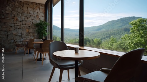 Modern cafe with tables and chairs overlooking a serene mountain landscape through large