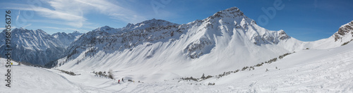 European Alps at skiing area Brandnertal, snowy mountains with blue sky (panorama)