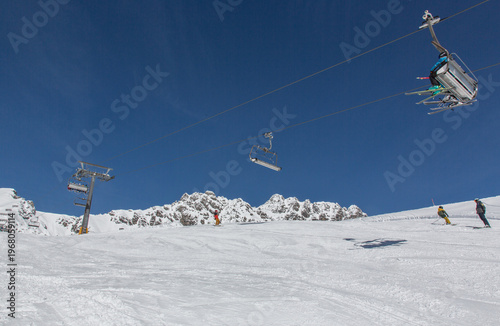 Chairlift at European Alps at skiing area Brandnertal, snowy mountains with blue sky