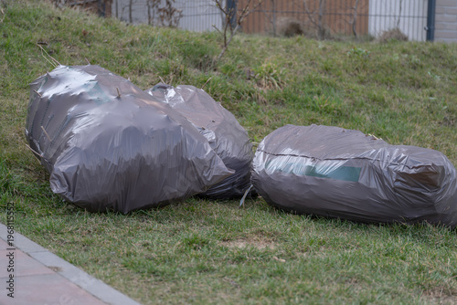 Garden waste bags on grass yard cleanup and landscaping maintenance result