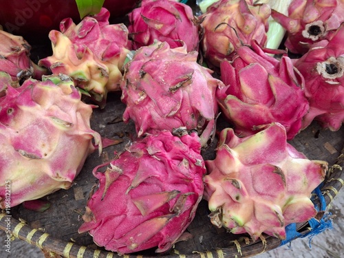 Dragon fruit (or pitaya), the fruit of a cactus plant native to Central and South America. Based on its striking red skin and dense scales, this fruit is likely a variety of red dragon fruit (Hylocere