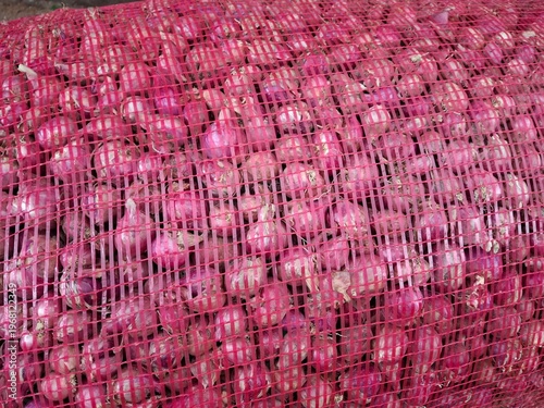 Red onions packed in red net sacks, which are commonly used to maintain air circulation so that the onions don't rot quickly.