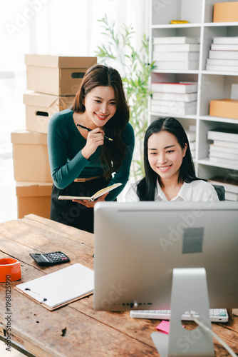Two young women running a small SME startup are checking inventory, packing products, and preparing for shipment.