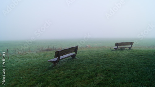 Bänke auf der Wiese im Nebel