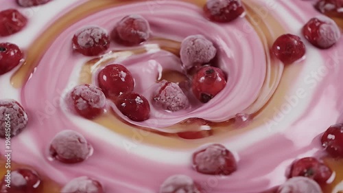 A pink liquid swirls around red berries, creating a textured, fluid dessert