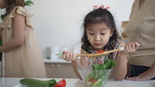 Daughter, mother and grandmother are preparing food together in the kitchen. Relationship, family, domestic life.
