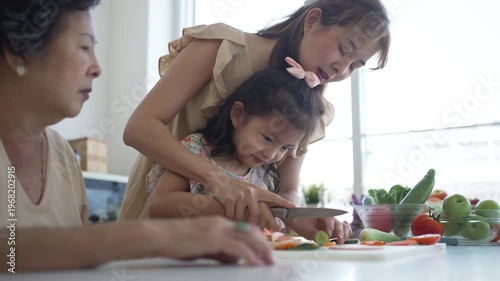 Daughter, mother and grandmother are preparing food together in the kitchen. Relationship, family, domestic life.