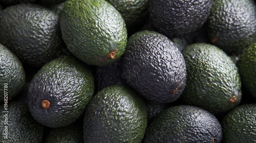 Pile of ripe and unripe avocados with textured skin closeup background