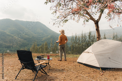Photos Solo man camping with tent and coffee overlooking mountain valley in countryside