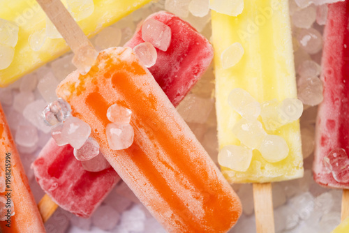 Colorful fruit ice pops on crushed ice, summer refreshment concept