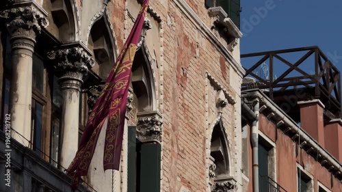 Slow motion dark red flag on historic stone building