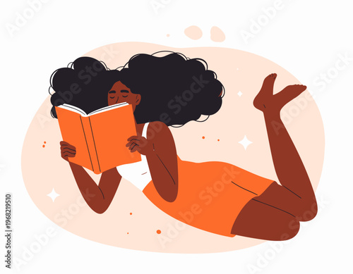 Young Black woman relaxing while reading an orange book, enjoying leisure time
