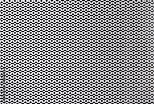 Weißes Lochgitter mit horizontalem Rautenmuster vor schwarzem Hintergrund, leicht verschmutzter Zustand