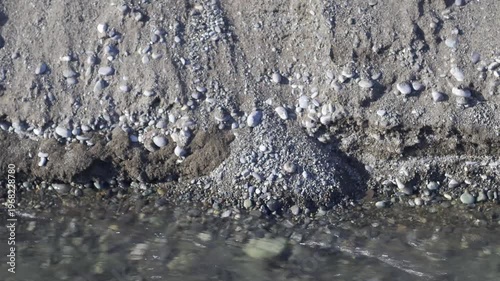 River stream eroding pebble beach and flowing into the sea