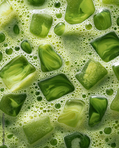 A tight macro shot of a matcha latte texture, top down view, with ice cubes, tea or small splash hitting the surface in soft light. Use slow motion for elegance.