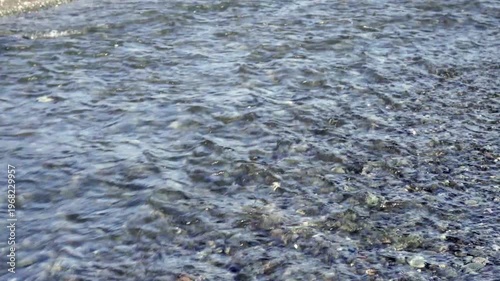 Crystal clear river water with varying depths and flow patterns