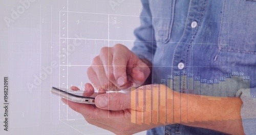 Tapping hands using phone screen against plain backdrop, showing floating charts over denim cuff