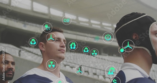 Standing four rugby players wearing navy jerseys and padded scrum cap in stadium, showing AR icons