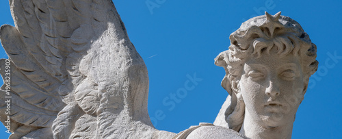 Fotografía Angel with wings against blue sky, symbolizing soul transition, afterlife, and spiritual passage between worlds in a conceptual composition