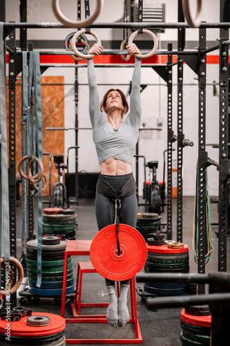 Wallpaper Mural Woman exercising weighted pull ups on gymnastic rings Torontodigital.ca