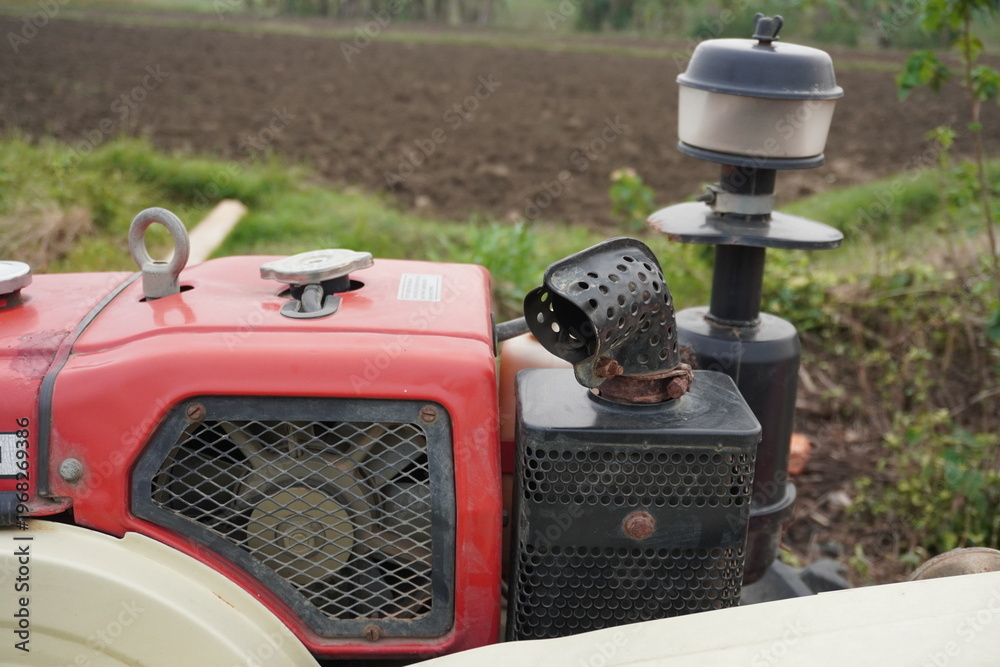 Fototapeta premium Red Mini Tractor with Engine Components in Field