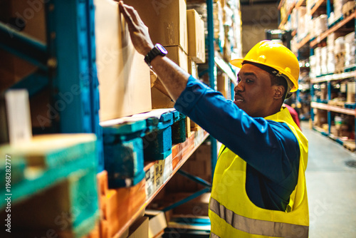 Warehouse worker organizing boxes on storage shelves