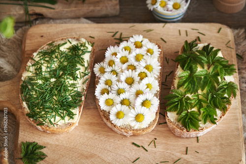 Sourdough bread with spring wild edible plants - ground elder, common daisy and crow garlic