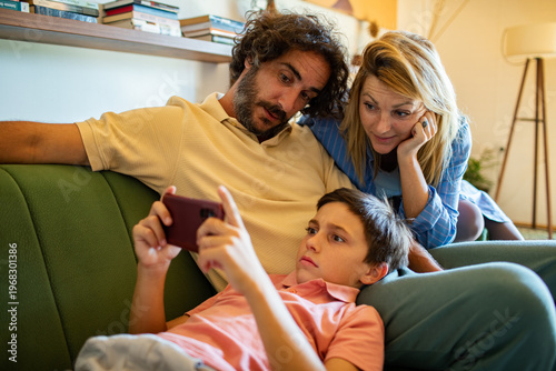 Parents watching their son on a smartphone at home