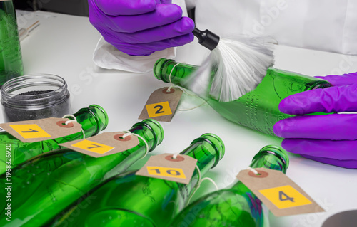 Police expert gets blood sample from a broken glass bottle in Criminalistic Lab, conceptual image