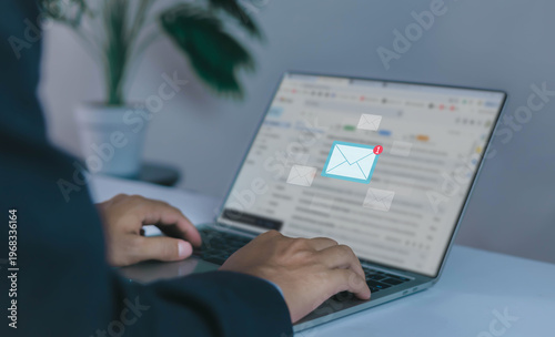 businessman checking email notifications on a smartphone represents digital communication, laptop messaging, and efficient information management in a modern technology-driven workplace.