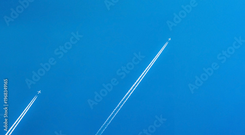 Foto Airplane with white condensation tracks