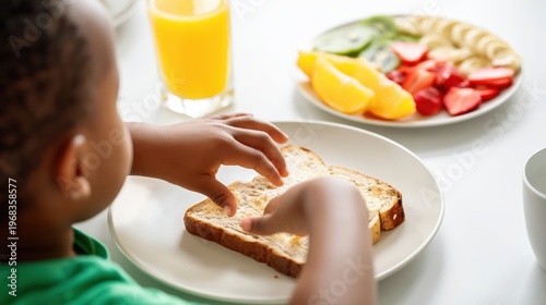 Child eating toast at breakfast table with fruit plate and orange juice in bright home kitchen.